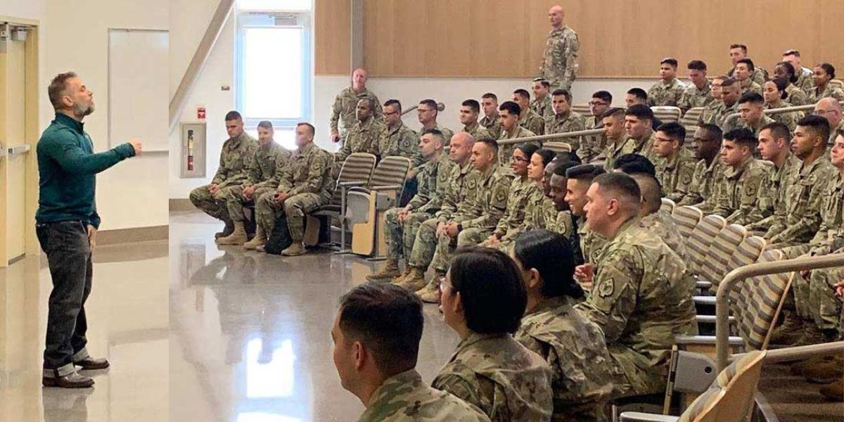 Damon Damoto addressing a group of military personnel seated in a lecture hall, engaging them in an interactive discussion.