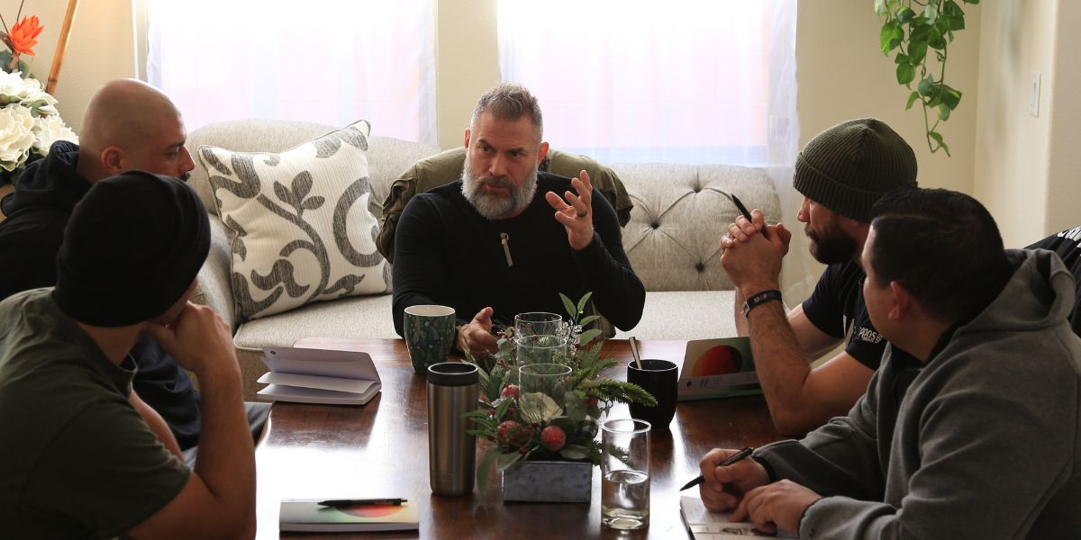 Damon Damato sitting with a group of veterans during a Veteran’s REset Experience at The Healing Sanctuary, guiding them through mentorship and personal transformation.