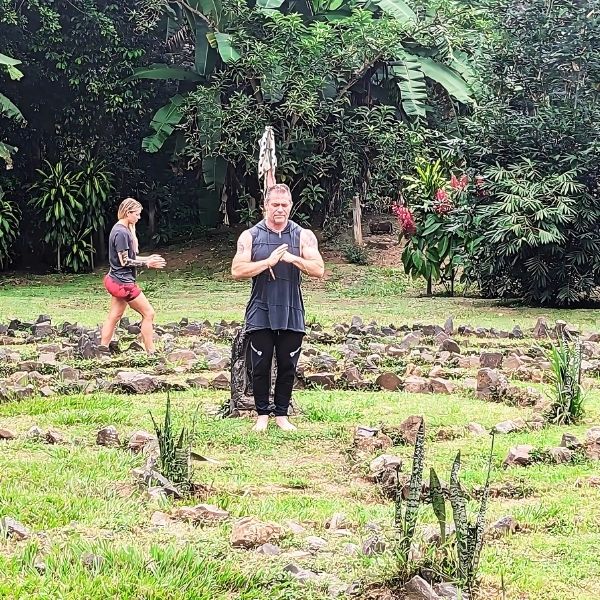 Damon Damato guiding guests through Qigong practice in the lush garden during The Healing Sanctuary's Tropical Retreat in Costa Rica.
