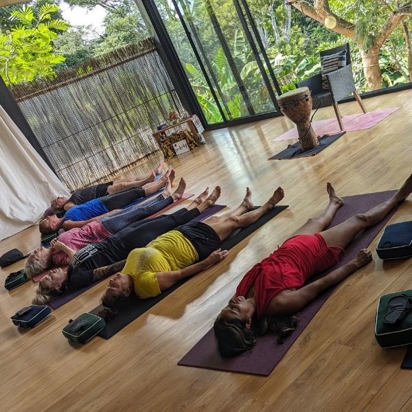 Guests practicing breathwork during The Healing Sanctuary's Tropical Retreat in the serene shala, surrounded by Costa Rica's lush rainforest.