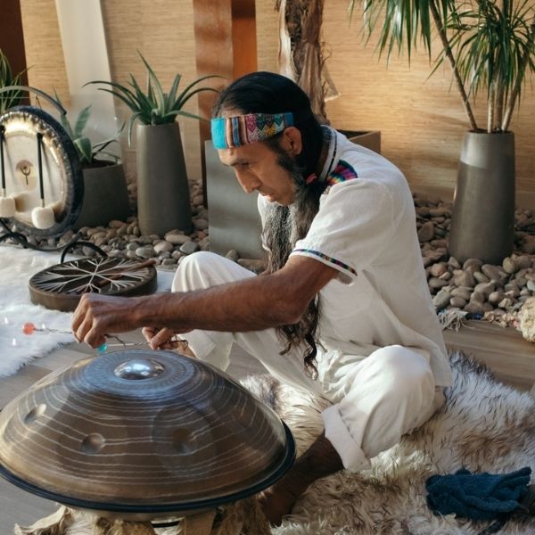 A Healing Sanctuary facilitator playing the handpan during a Live Community REset Experience, creating soothing, meditative sounds for deep relaxation and inner healing.
