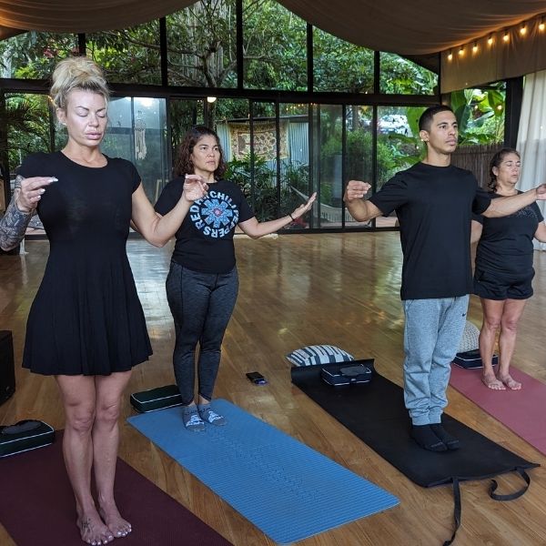 Guests practicing Qigong in the Costa Rica yoga shala during The Healing Sanctuary’s Tropical Retreat.