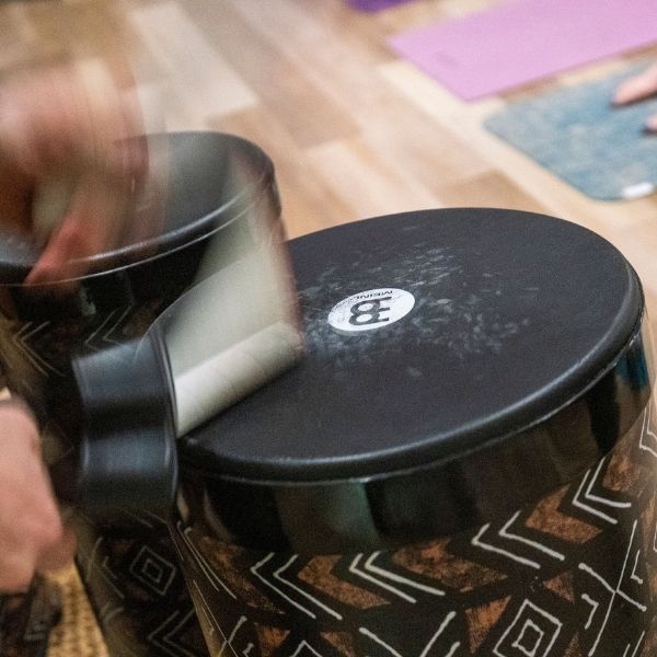 Close-up of a facilitator playing percussion drums during a sound healing session at The Healing Sanctuary’s Live Community REset Experience.
